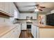 Bright kitchen features white cabinets, stainless steel appliances, and a ceiling fan with light fixture at 1137 Eagles Nest Cir, Carrollton, GA 30116
