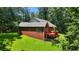 View of brick home with backyard, deck and mature surrounding trees at 1950 Lower Burris Rd, Canton, GA 30114