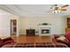 Living room with hardwood floors, a fireplace, a ceiling fan, and an inviting red sofa at 1950 Lower Burris Rd, Canton, GA 30114