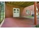 A covered patio with brick flooring provides an outdoor living space adjacent to the home's backyard at 1950 Lower Burris Rd, Canton, GA 30114