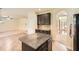 Granite-topped kitchen island with dark cabinets and a view into the living room at 3677 Trillium Forest Dr, Snellville, GA 30039