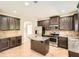Well-equipped kitchen with dark cabinetry, stainless appliances, and a granite island at 3677 Trillium Forest Dr, Snellville, GA 30039