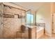 Close-up of shower with stylish tile, glass enclosure, and built-in niche next to a soaking tub at 3677 Trillium Forest Dr, Snellville, GA 30039