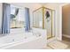 Bright bathroom featuring a soaking tub with jets, a glass-enclosed shower, and natural light from the window at 3072 Oaktree Ln, Duluth, GA 30096