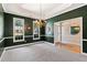 Elegant dining room with green walls, white trim, plush carpet, and a chandelier at 3072 Oaktree Ln, Duluth, GA 30096