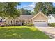 Charming single-story home with a well-manicured lawn, a two-car garage, and lush landscaping at 3072 Oaktree Ln, Duluth, GA 30096