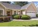 Close-up of the front yard featuring the front door, trimmed hedges, and a two-car garage at 3072 Oaktree Ln, Duluth, GA 30096