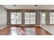 Bright living room featuring hardwood flooring, neutral walls, and natural light streaming through the large windows at 3625 Ennfield Lane Ln, Duluth, GA 30096