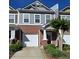 Charming two-story townhome with brick and gray siding, a single-car garage, and a well-maintained front yard at 776 Tulip Poplar Way, Lawrenceville, GA 30044