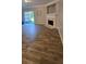 Open-concept living room with wood-look tile flooring, a fireplace, and sliding glass doors to the patio at 776 Tulip Poplar Way, Lawrenceville, GA 30044