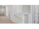 Upstairs hallway featuring a staircase, white walls, and neutral carpet at 8587 Secretariat Dr, Lithonia, GA 30058
