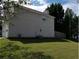 Angled side view of the house with a fenced in back yard and manicured lawn at 857 Asbury Trl, Lithonia, GA 30058