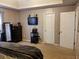 Spacious primary bedroom with closet doors, dark furniture, and a mounted television at 857 Asbury Trl, Lithonia, GA 30058