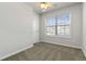 This bedroom offers neutral walls, carpet flooring, and a window overlooking the exterior, next to a closed door at 3170 Cedar Glade Ln, Buford, GA 30519