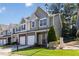 Street view of a two-story townhome showing landscaping, brick accents, and inviting curb appeal at 3170 Cedar Glade Ln, Buford, GA 30519
