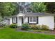 Quaint home exterior with dark shutters, white siding, and attractive landscaping in a lush setting at 1091 Napier St, Atlanta, GA 30316