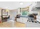 Functional kitchen featuring white cabinets, a gas range, and a cozy breakfast nook with a view at 1091 Napier St, Atlanta, GA 30316