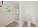 Well lit bathroom features glass shower door, white toilet and modern tile floor at 179 Hunters Crk, Dallas, GA 30157