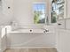 Bright bathroom features soaking tub with tile flooring and bright windows at 179 Hunters Crk, Dallas, GA 30157