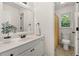 Bright bathroom featuring a white vanity, a framed mirror, and a toilet in an alcove with a patterned shower curtain at 179 Hunters Crk, Dallas, GA 30157