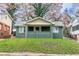Charming craftsman-style house with painted brick facade and welcoming front porch on a well-manicured lawn at 1174 Donnelly Sw Ave, Atlanta, GA 30310