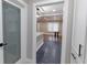 Modern hallway with view to the open concept room, featuring dark tile floors, laundry door, and storage at 1174 Donnelly Sw Ave, Atlanta, GA 30310
