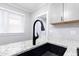 Close-up on kitchen featuring granite countertop, modern black faucet, subway tile backsplash, and a bright window at 1174 Donnelly Sw Ave, Atlanta, GA 30310