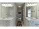 Bright bathroom featuring dual vanities with white countertops and modern lighting fixtures at 1614 Summersweet Ln, Dacula, GA 30019