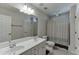 Bathroom with dual sinks, white cabinets, a toilet and a shower and tub combination at 1614 Summersweet Ln, Dacula, GA 30019