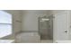 Bathroom features a glass door shower, garden tub, and window at 1614 Summersweet Ln, Dacula, GA 30019
