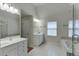 Spacious bathroom with a glass-enclosed shower, soaking tub, and large vanity with mirror at 1614 Summersweet Ln, Dacula, GA 30019
