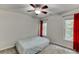 Bright bedroom with two windows, neutral-colored carpet, and red curtains at 1614 Summersweet Ln, Dacula, GA 30019