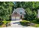 Charming brick home with a two-car garage, mature trees, and manicured lawn at 1614 Summersweet Ln, Dacula, GA 30019