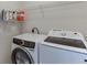 Laundry room with white washer and dryer and wire rack shelving at 1614 Summersweet Ln, Dacula, GA 30019