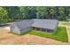 The aerial shot reveals the home's exterior, back porch, landscaping, and surrounding green lawn at 1943 Lake Chase Ln, Jonesboro, GA 30236