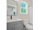 Bathroom with gray vanity and modern fixtures, window, and a partial view of the bedroom at 1943 Lake Chase Ln, Jonesboro, GA 30236