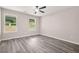 Empty bedroom is bright with backyard views, neutral paint, ceiling fan, and wood-look floors at 1943 Lake Chase Ln, Jonesboro, GA 30236