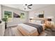 A bright bedroom is furnished with neutral colored furniture, wall art, and backyard views at 1943 Lake Chase Ln, Jonesboro, GA 30236