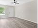Living room featuring gray wood floors, a ceiling fan, a window, and a white door at 1943 Lake Chase Ln, Jonesboro, GA 30236