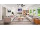 Cozy living room with neutral furniture, fireplace, ceiling fan, and backyard views at 1943 Lake Chase Ln, Jonesboro, GA 30236