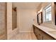Bathroom featuring double vanity, walk-in shower with stylish neutral tiling, and natural light at 3415 Crop Corner Rd, Suwanee, GA 30024