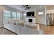 Cozy living room featuring fireplace, large sofa, ceiling fan, and large windows at 3415 Crop Corner Rd, Suwanee, GA 30024