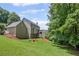 Landscaped backyard featuring a well-maintained lawn, mature trees, and a multi-level deck at 1079 Angel Ln, Powder Springs, GA 30127