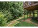 Lush backyard with an elevated deck, green grass, and lots of trees and foliage at 1079 Angel Ln, Powder Springs, GA 30127