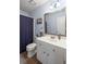 Bathroom featuring a white vanity with ample storage, decorative mirror and brown tile flooring at 1079 Angel Ln, Powder Springs, GA 30127