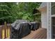 Outdoor deck featuring a grill for outdoor cooking and views of the trees at 8189 N Pine Cone N Dr, Villa Rica, GA 30180