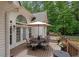 Outdoor deck features a dining table and chairs, and a tranquil view of the surrounding greenery at 8189 N Pine Cone N Dr, Villa Rica, GA 30180