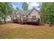 Backyard view showcasing a white home with a large wooden deck and a fenced yard at 8189 N Pine Cone N Dr, Villa Rica, GA 30180