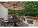 Outdoor deck featuring a dining set and an umbrella, perfect for enjoying the surrounding lush greenery at 8189 N Pine Cone N Dr, Villa Rica, GA 30180