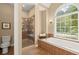 Bathroom featuring a soaking tub, glass-enclosed shower, and neutral tile design at 8189 N Pine Cone N Dr, Villa Rica, GA 30180